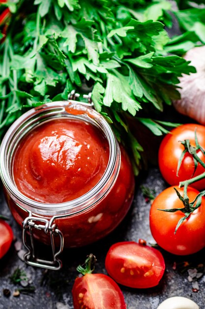 Salsa di pomodoro in vasetto di vetro con prezzemolo e aglio