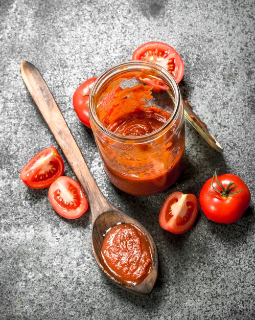 Salsa di pomodoro in vaso di vetro con cucchiaio.