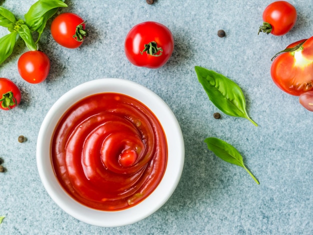 Salsa di pomodoro ketchup in una ciotola con peperoncino basilico e pomodori Ingredienti per cucinare il ketchup