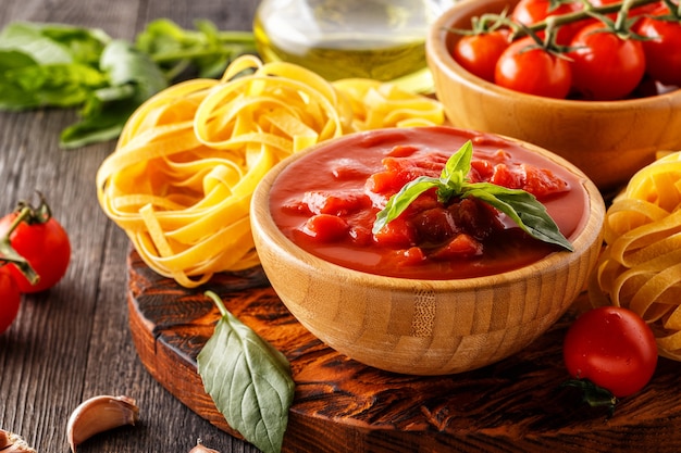 salsa di pomodoro, pasta, pomodori, aglio, olio d'oliva sul legno vecchio.