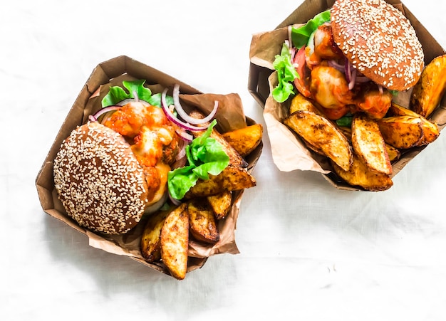 Salsa di pomodoro polpette mozzarella formaggio panini integrali hamburger e patate al forno su sfondo chiaro vista dall'alto