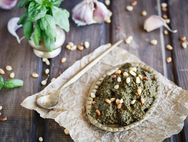 Salsa e ingredienti di pesto su fondo di legno.