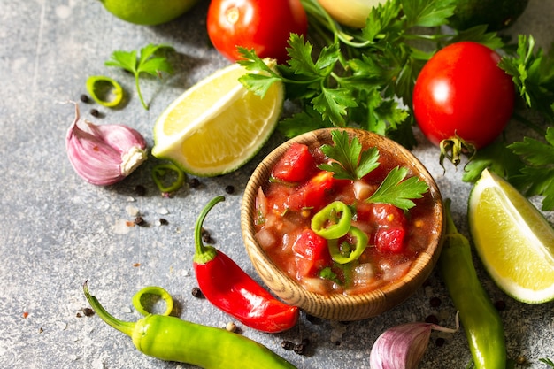 Salsa messicana tradizionale latinoamericana con ingredienti su un tavolo di pietra chiara