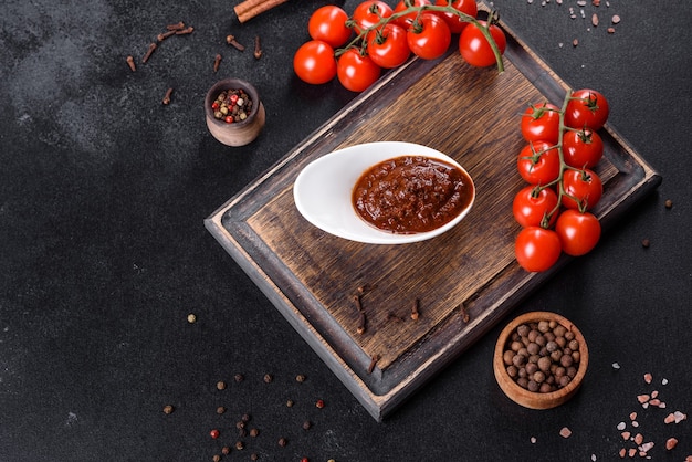 Salsa rossa o ketchup in una ciotola e ingredienti per cucinare