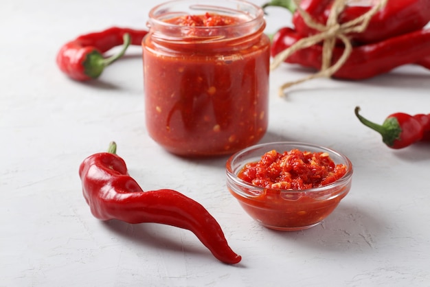 Salsa tradizionale adjika con peperoncino piccante, pasta harissa su sfondo chiaro