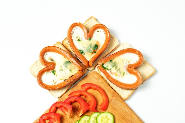 Salsicce a forma di cuore, alla prova, con verdure tritate, isolate, vista dall'alto