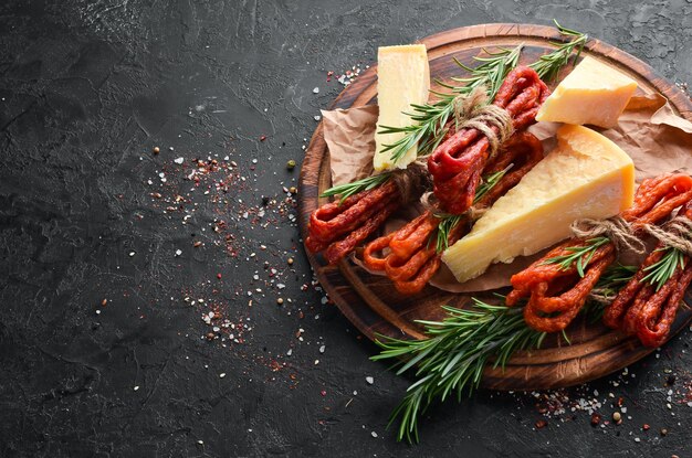 Salsicce affumicate con formaggio su fondo di pietra nera Parmigiano Kabanosy Vista dall'alto Spazio libero per il testo