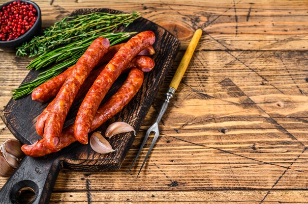 Salsicce affumicate di suino con aggiunta di erbe aromatiche fresche e spezie. fondo in legno. Vista dall'alto. Copia spazio.