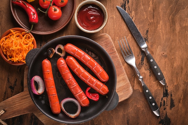 Salsicce alla griglia in padella con cipolle e verdure