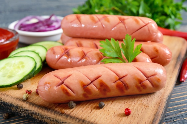 Salsicce alla griglia succose, salsa e verdure fresche. Salsicce per hot dog. Cibo di strada.