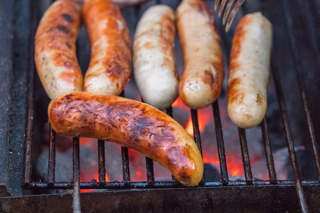 Salsicce alla griglia sulla griglia del barbecue. Messa a fuoco selettiva.