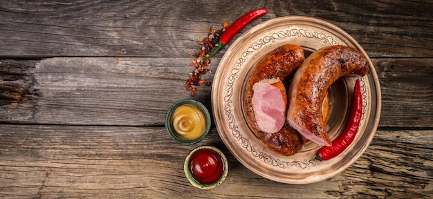 Salsicce appetitose affumicate su una tavola di legno Prodotto naturale da fattoria biologica Vista dall'alto Formato banner lungo