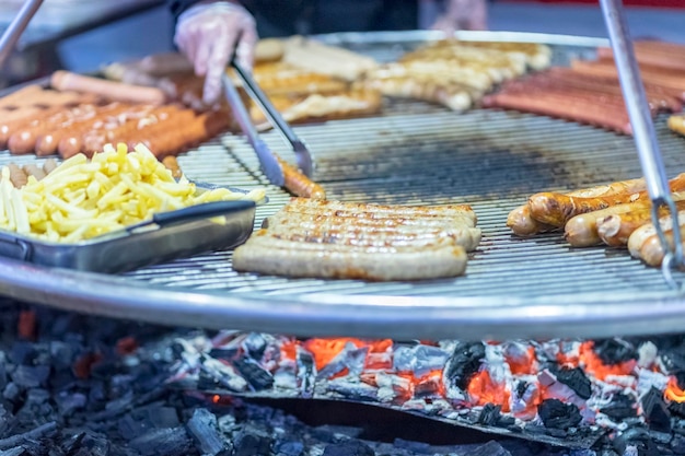 Salsicce barbecue e patatine fritte cotte su carbone