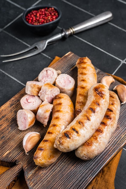 Salsicce di carne di maiale Bratwurst alla griglia tedesche su una tavola di legno Sfondo di legno Vista dall'alto