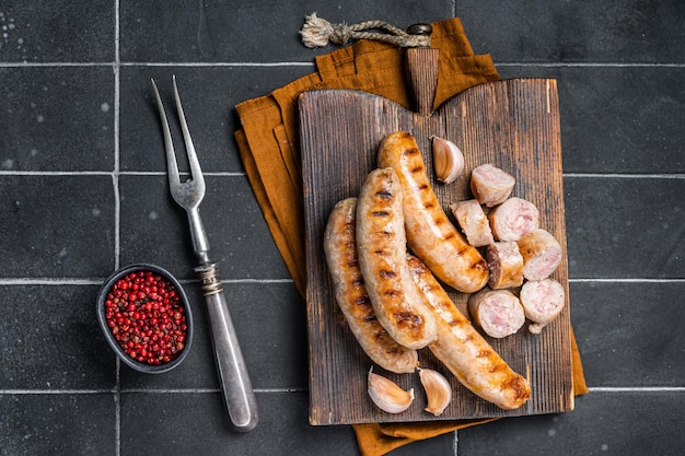 Salsicce di carne di maiale Bratwurst alla griglia tedesche su una tavola di legno Sfondo di legno Vista dall'alto