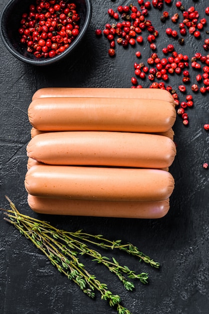 Salsicce di pollo classiche a base di carne cruda. Superficie nera. Vista dall'alto