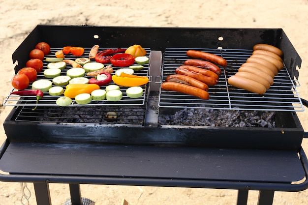 Salsicce e verdure sul primo piano della griglia del barbecue