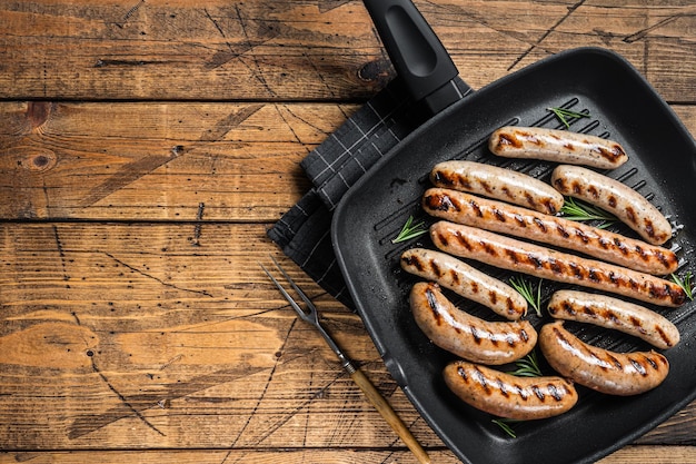 Salsicce fatte in casa alla griglia con carne di maiale agnello e pollo carne macinata in una padella alla griglia Sfondo in legno Vista dall'alto Spazio per la copia