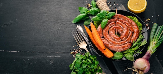 Salsicce fritte al barbecue con verdure fresche su uno sfondo di legno Vista dall'alto Spazio di copia