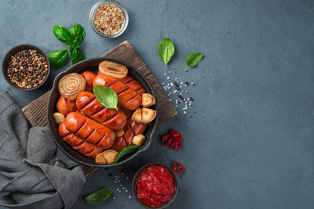 Salsicce fritte con cipolle e aglio in padella