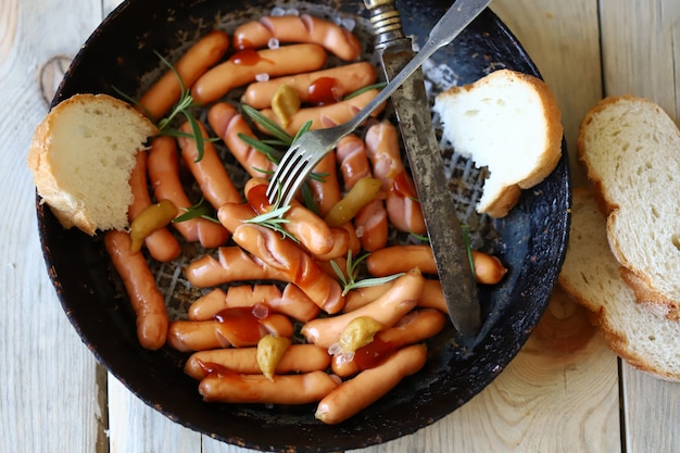 Salsicce fritte con crosta croccante. Spuntino alla birra. Salsicce tedesche speziate in padella.