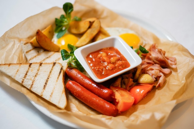 Salsicce fritte con crostini di pancetta e uova Il concetto di una deliziosa ricca colazione fatta in casa servita in un ristorante