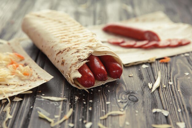 Salsicce piccanti in pita su un tavolo di legno