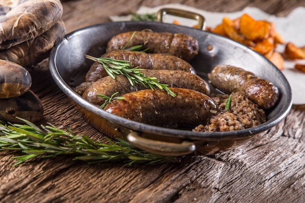 Salsicce.Salsiccia di maiale arrosto in padella con patate e rosmarino.