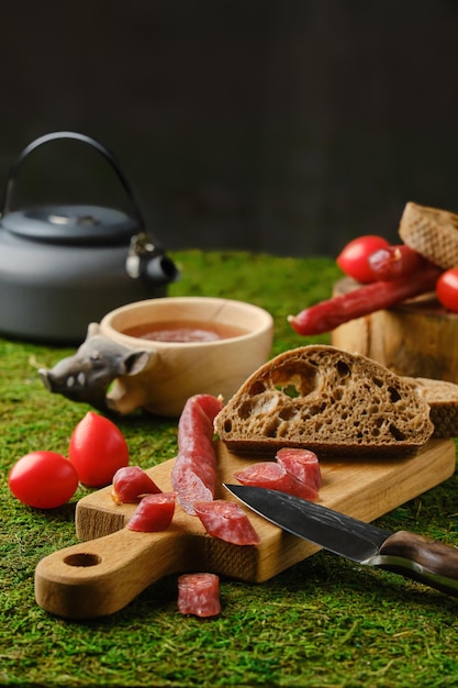 Salsicce secche con pane e pomodori su muschio