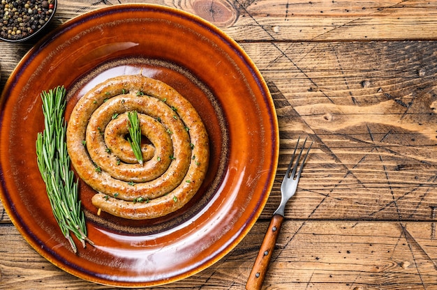 Salsiccia a spirale alla griglia di carne di maiale e manzo su un piatto rustico.