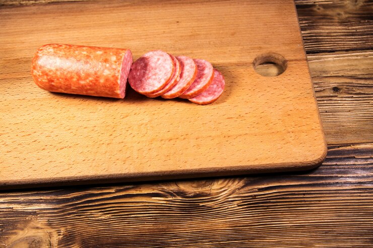 Salsiccia affettata sul tagliere sulla tavola di legno