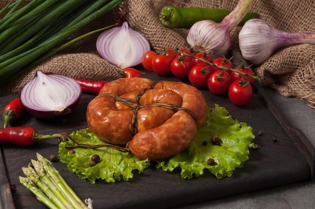 Salsiccia cotta nel forno a legna decorata con verdure fresche