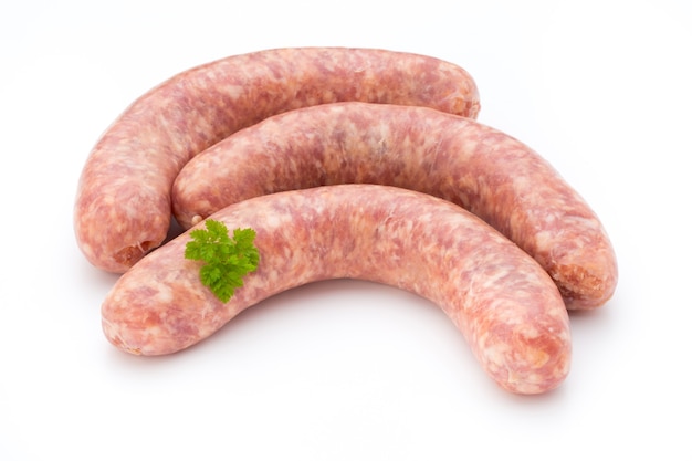 Salsiccia cruda con foglia di prezzemolo isolato su bianco.