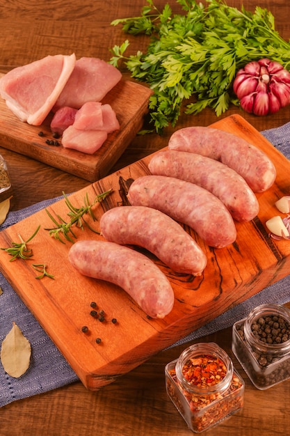 Salsiccia di coscia di maiale brasiliana sul tagliere di legno con spezie e ingredienti