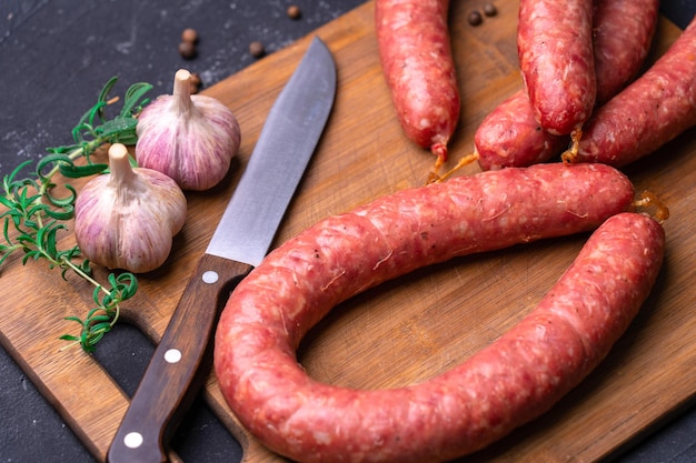 Salsiccia fatta in casa su un tagliere. Bellissimi anelli di salsiccia di Cracovia