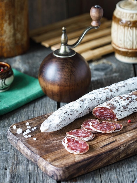 Salsiccia Fuet tagliata a fette con spezie su una tavola di legno rustica Prelibatezza di maiale essiccata tradizionale spagnola con uno stampo nobile