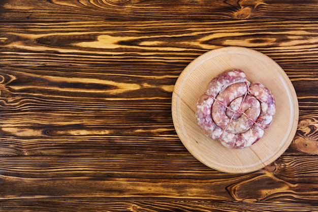 Salsiccia grezza fresca su di legno