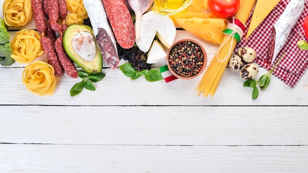 Salsiccia italiana formaggio e verdure su uno sfondo di legno bianco Vista dall'alto Copia spazio