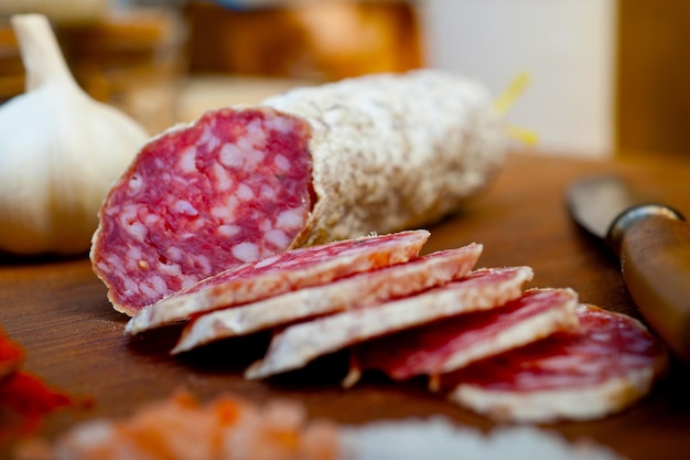 Salsiccia stagionata del salame italiano tradizionale affettata su una tavola di legno