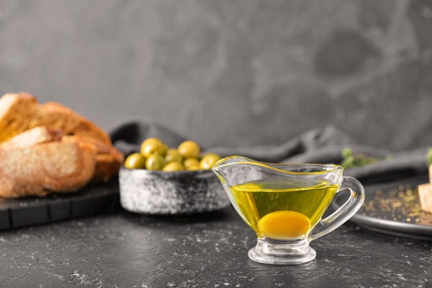 Salsiera di gustoso olio d'oliva su oscurità