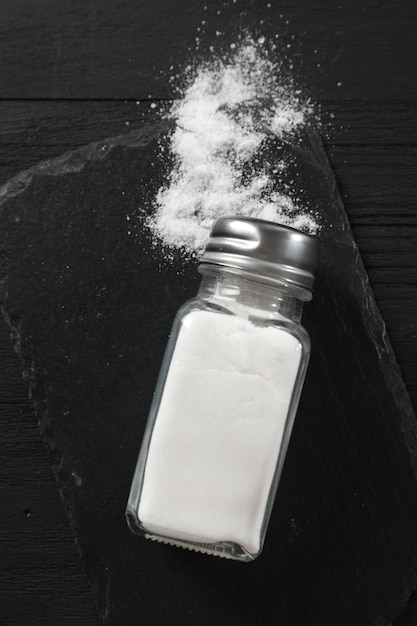 Salt shaker su un tavolo di legno nero