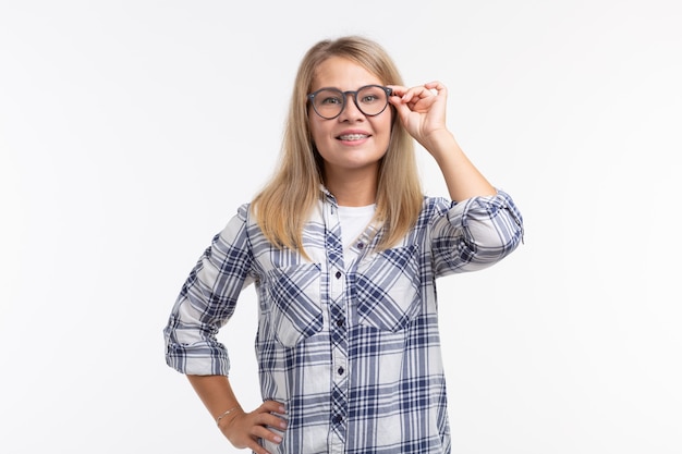 Salute dei denti, odontoiatria e correzione del morso - Donna sorridente felice con gli occhiali con le parentesi graffe su bianco