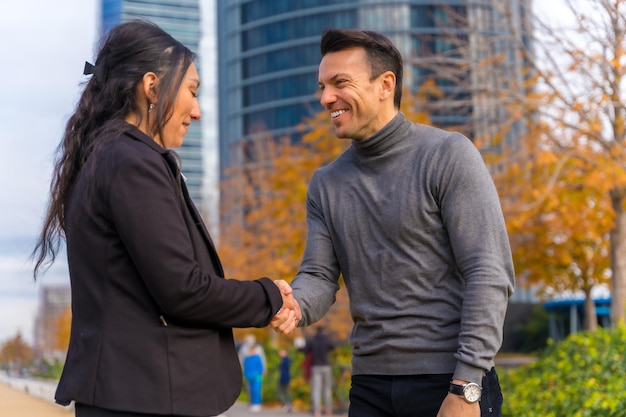 Saluto multietnico dell'uomo d'affari e della donna di affari agitando le mani buon ambiente di lavoro