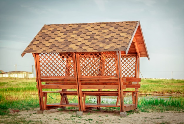 Salva Scarica Anteprima Nuovo gazebo in legno su una costa sabbiosa di stagno