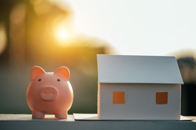 Salvadanaio e un modello di casa, concetto Risparmiare denaro per la casa e gli immobili.