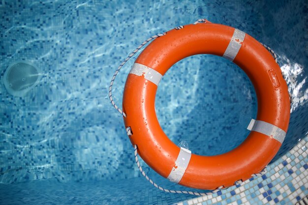 salvagente arancione in piscina salvagente arancione su uno sfondo d'acqua Concetto di vacanza estiva