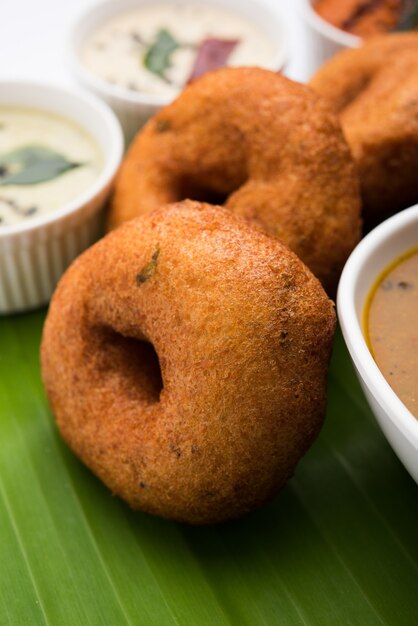 Sambar vada o Medu Vada, un popolare cibo dell'India meridionale servito con chutney di cocco verde, rosso e su sfondo lunatico. Messa a fuoco selettiva