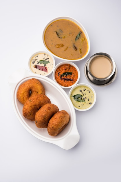 Sambar vada o Medu Vada, un popolare cibo dell'India meridionale servito con chutney di cocco verde, rosso e su sfondo lunatico. Messa a fuoco selettiva