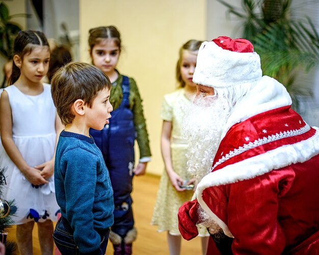 San Pietroburgo, Russia - 23 dicembre 2016: Auguri di Capodanno per bambini. Bambini che giocano con la fanciulla di neve e Babbo Natale. Emozioni bambini brillanti nella scuola di danza.