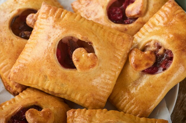 San Valentino a forma di cuore Torte a mano Mini pasta sfoglia o torte a mano ripiene di mela e cospargere di zucchero a velo nel piatto Idea per uno spuntino romantico fatto in casa San Valentino Vista dall'alto Copia spazio